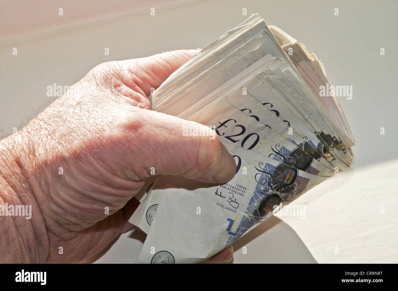 Caisse - paquet de sterling billets détenus dans une main d'argent au Royaume-Uni Banque D'Images