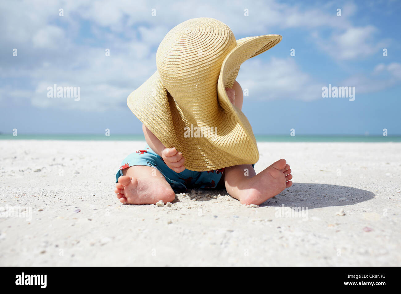 Bébé Garçon jouant avec le chapeau de soleil sur la plage Photo Stock -  Alamy