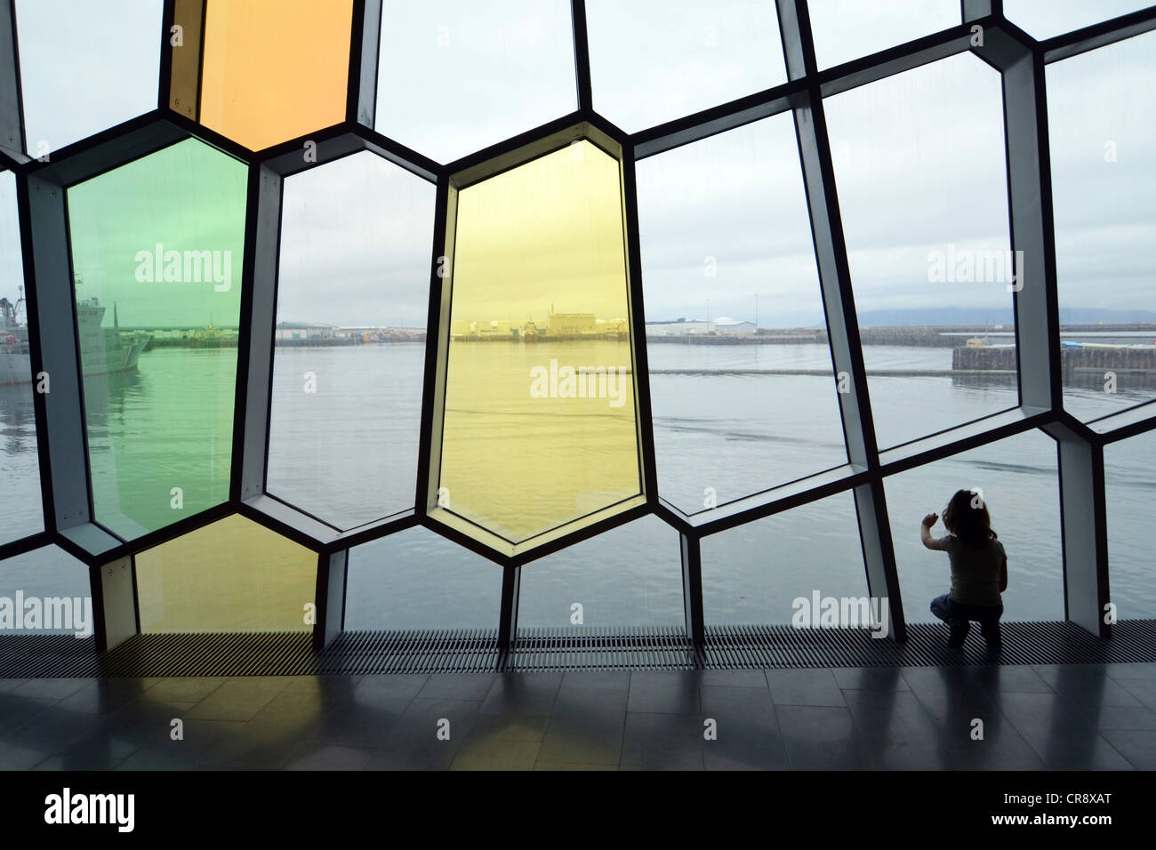 Enfant en regardant à travers les fenêtres en forme d'abeilles dans la façade, nouveau Harpa concert hall à Reykjavik, Islande, Europe Banque D'Images