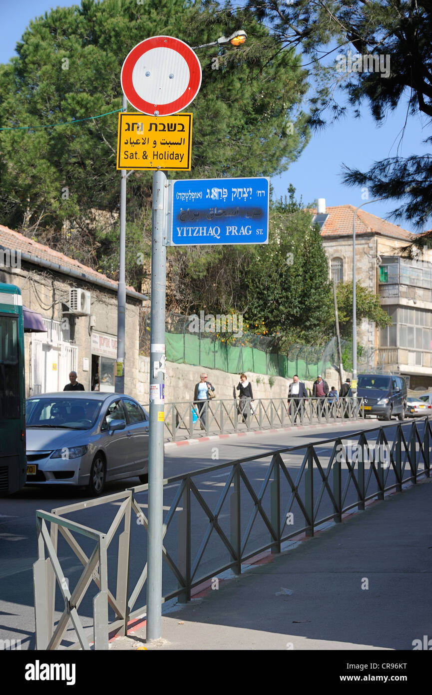 Nom de rue signe avec le nom arabe, pulvérisé sur les Juifs orthodoxes à l'arrière, Jérusalem, Israël, Moyen Orient Banque D'Images