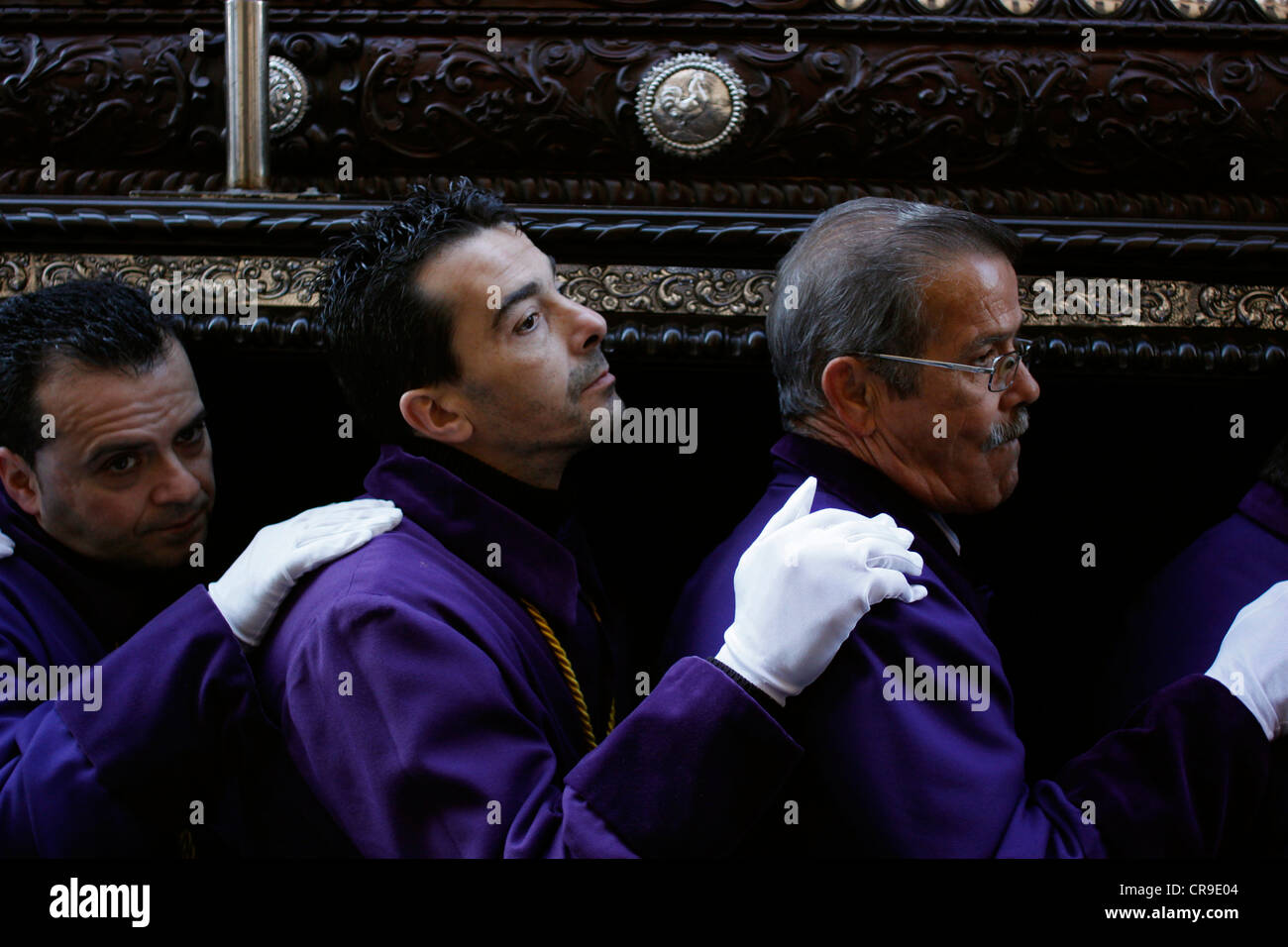 Les hommes portent un trône sur leurs épaules lors d'une procession de la Semaine Sainte de Pâques à Puente Genil, dans la province de Cordoba, Espagne Banque D'Images
