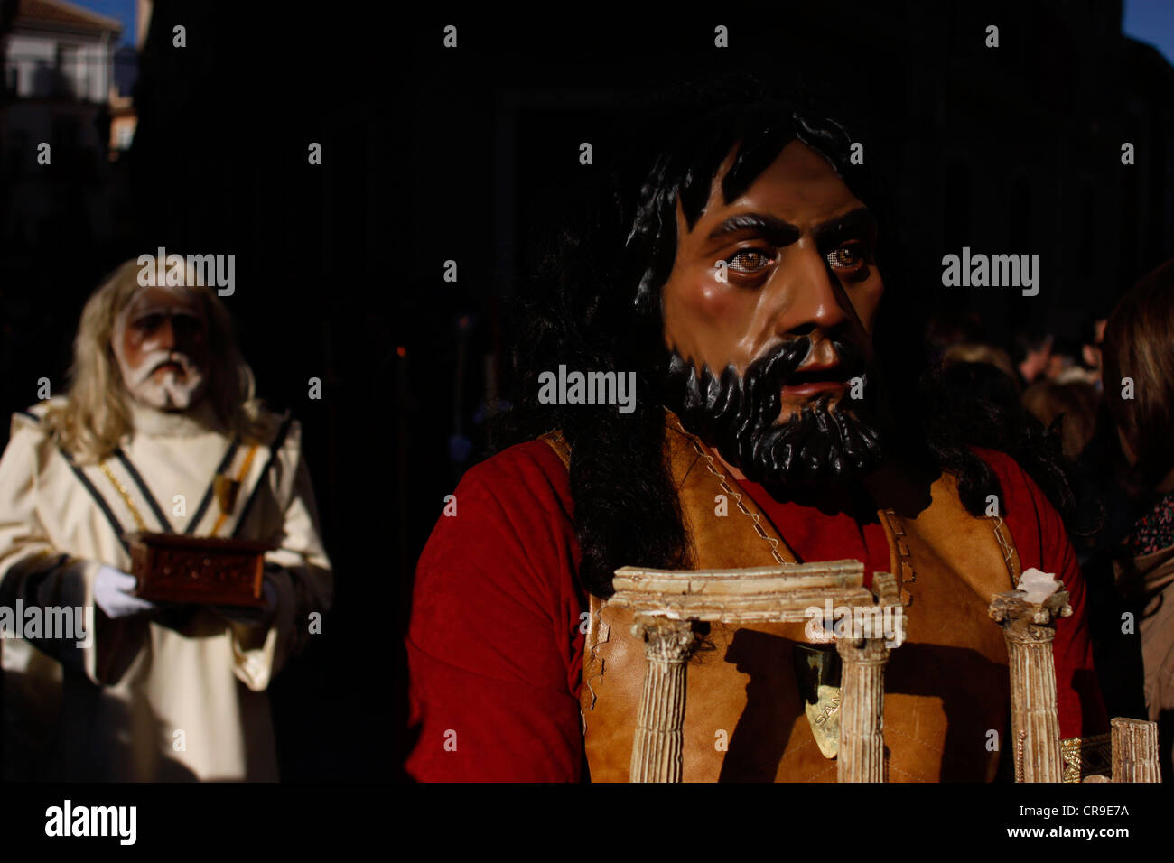 Des hommes masqués déguisés en personnages bibliques à pied dans une rue au cours d'une procession de la Semaine Sainte de Pâques à Puente Genil, Espagne. Banque D'Images