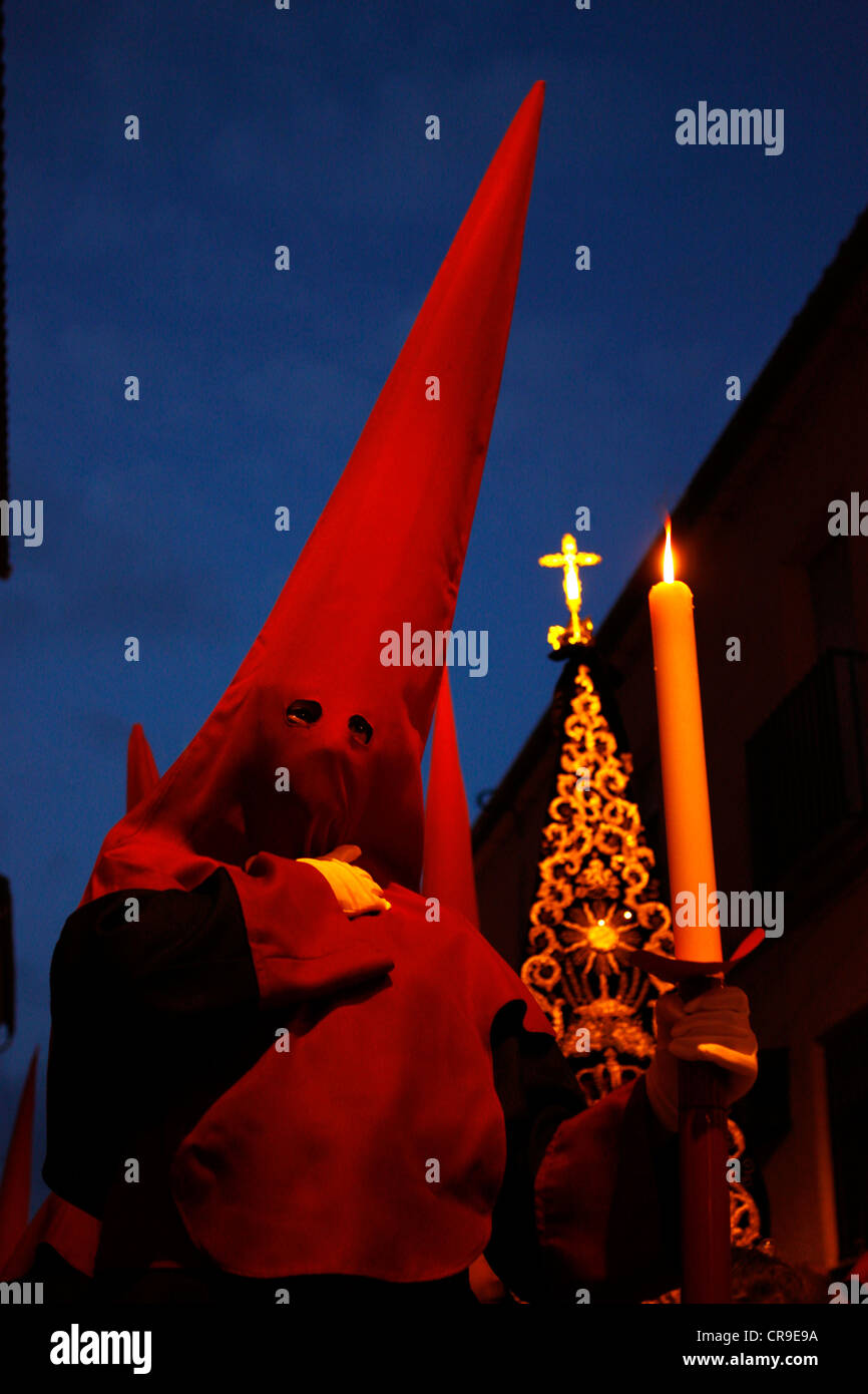 Le pénitent est titulaire d'une bougie lors d'une procession de la Semaine Sainte de Pâques à Puente Genil, dans la province de Cordoba, Espagne Banque D'Images