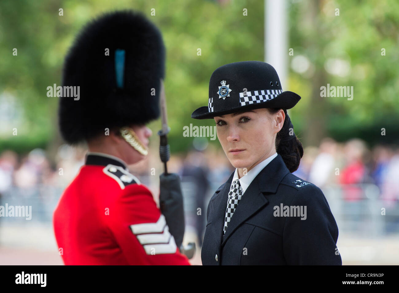 Agent de police métropolitaine femelle en face d'un gardes irlandais dans le centre commercial pour la parade la couleur. Le Mall, Londres, Royaume-Uni. Banque D'Images