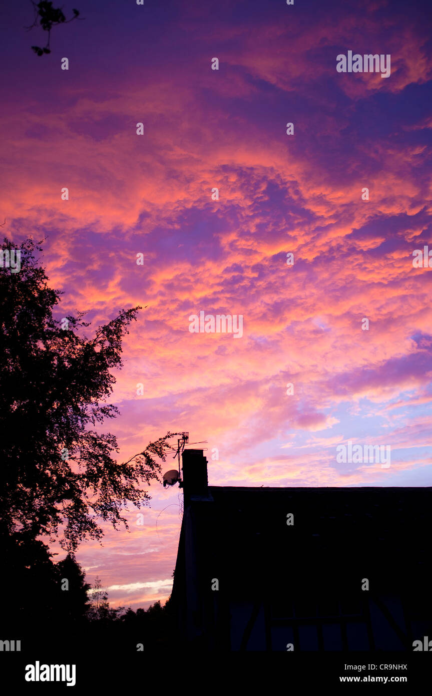 Coucher du soleil rouge profond sur une maison d'habitation Banque D'Images