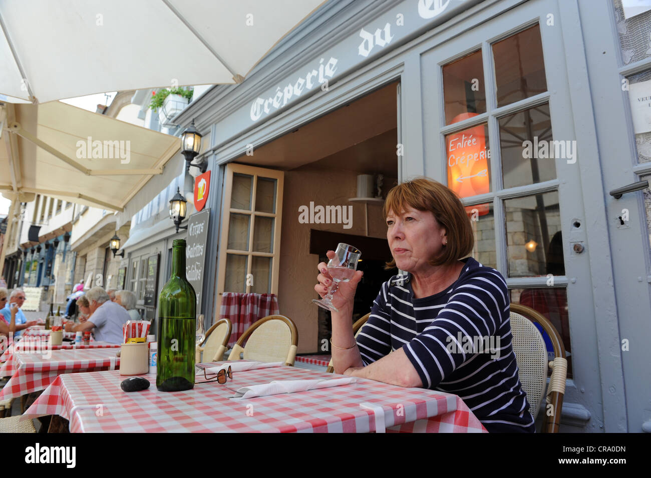 Femme buvant du vin dans un café français à Josselin, Bretagne, France Banque D'Images