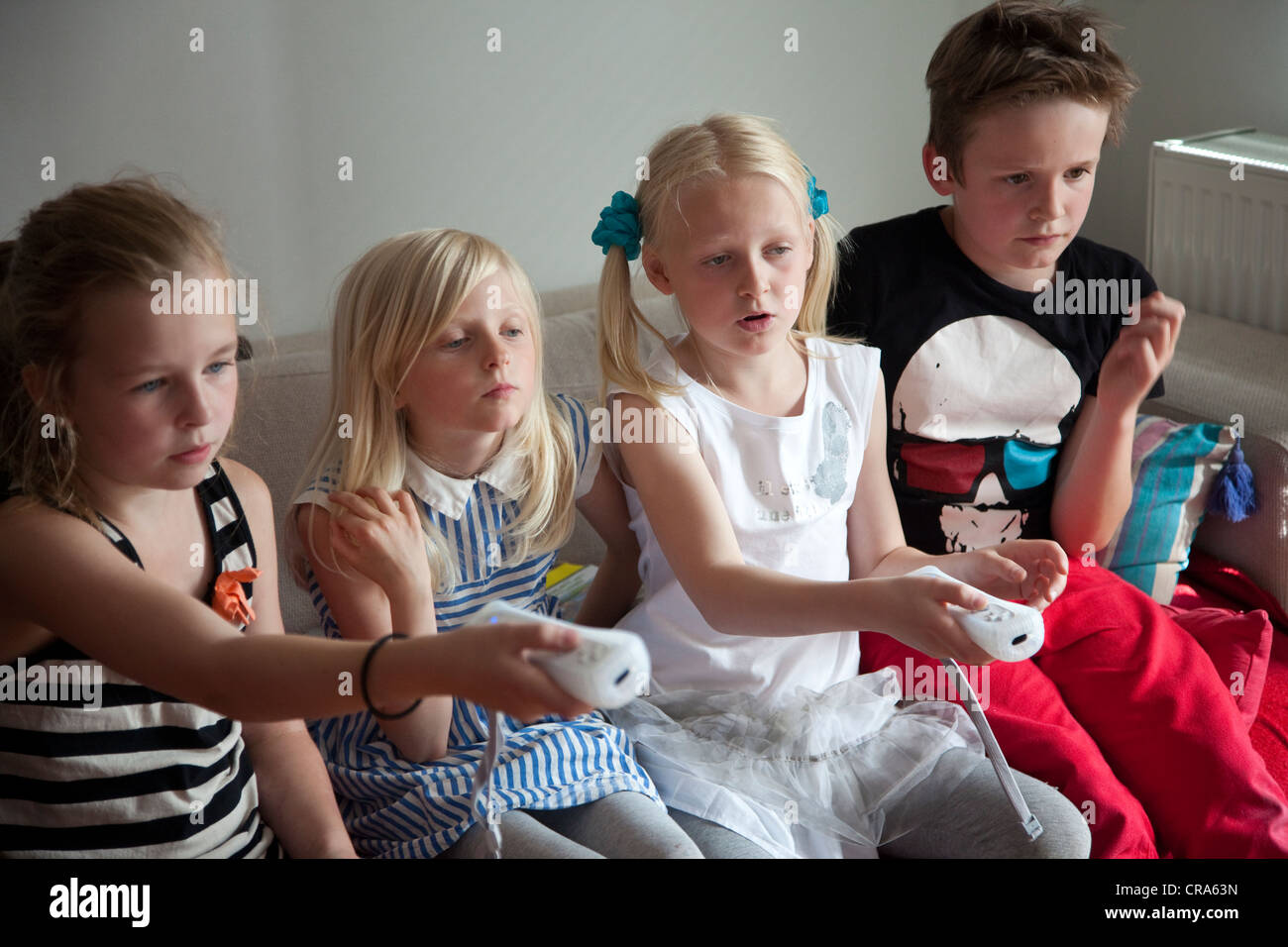 Groupe d'enfants jouer a la console de jeux Nintendo Wii à la maison. Banque D'Images