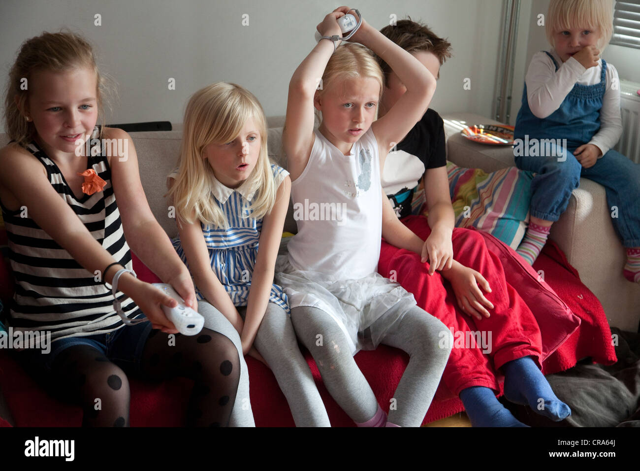 Groupe d'enfants jouer a la console de jeux Nintendo Wii à la maison. Banque D'Images