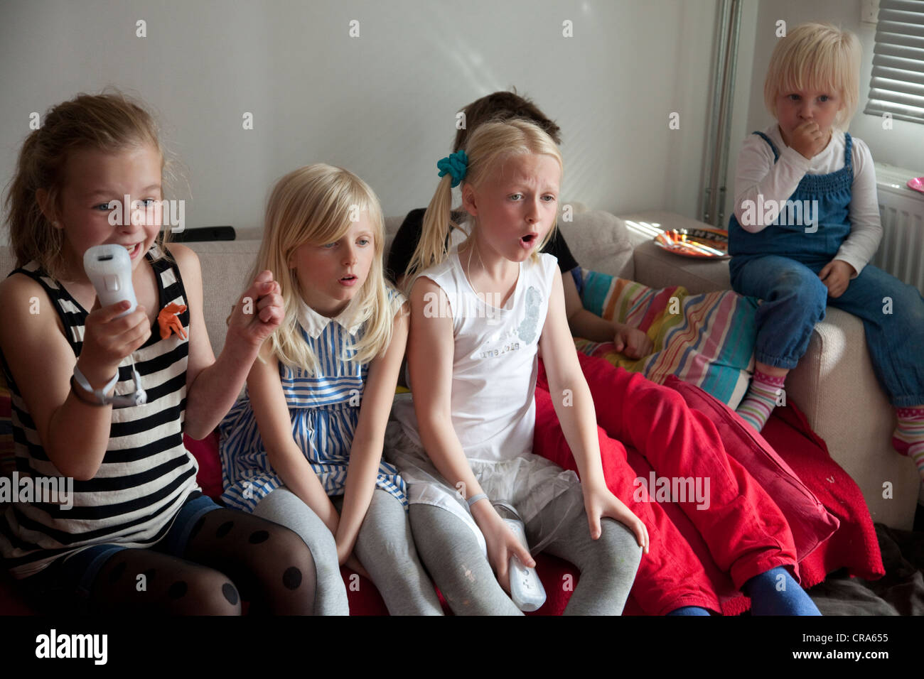 Groupe d'enfants jouer a la console de jeux Nintendo Wii à la maison. Banque D'Images