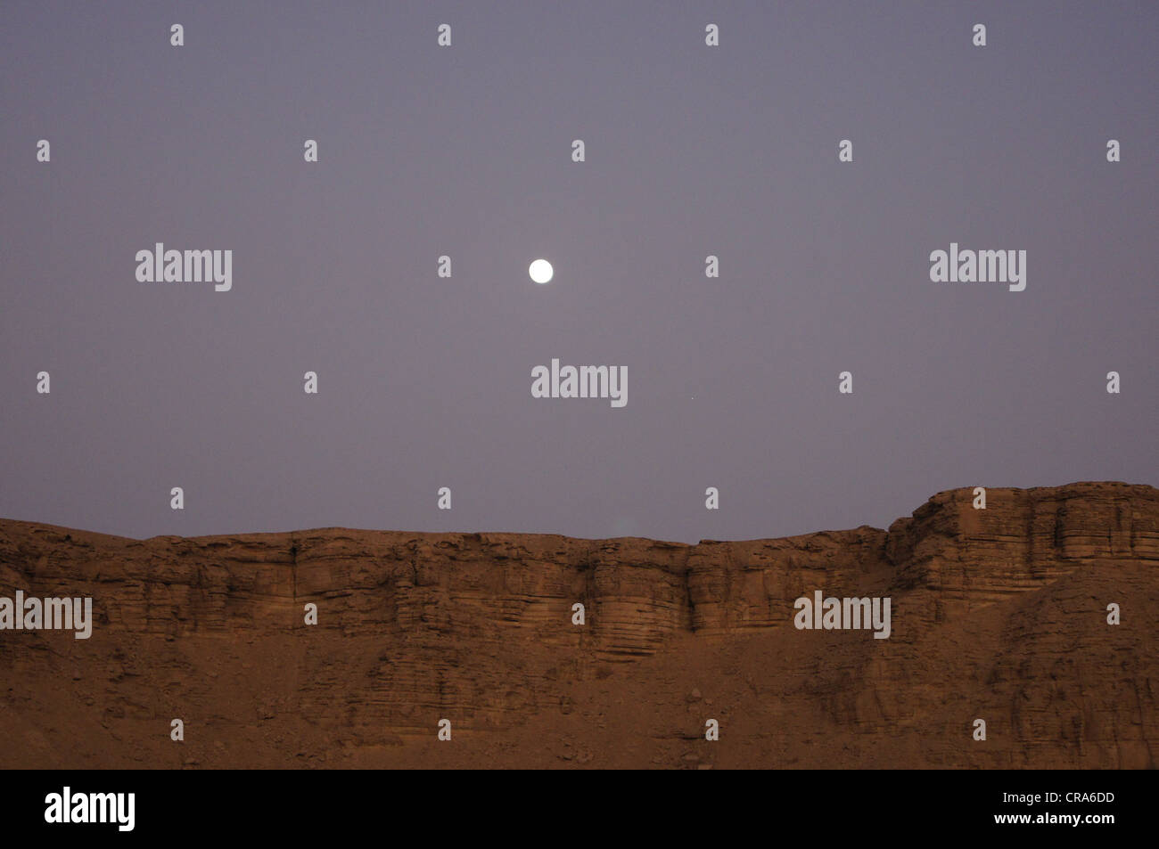 La lune qui sort plus de formations rocheuses dans le désert de sable rouge - Riyadh, Royaume d'Arabie Saoudite Banque D'Images