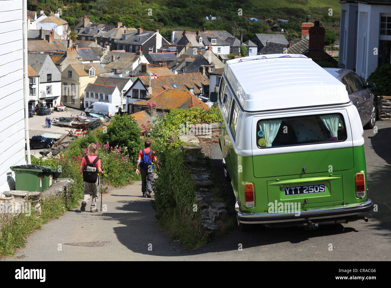 Port Isaac, North Cornwall, un VW camper van stationné sur une rue étroite avec les randonneurs et les promeneurs en direction de la ville de la baie en bord de mer Banque D'Images