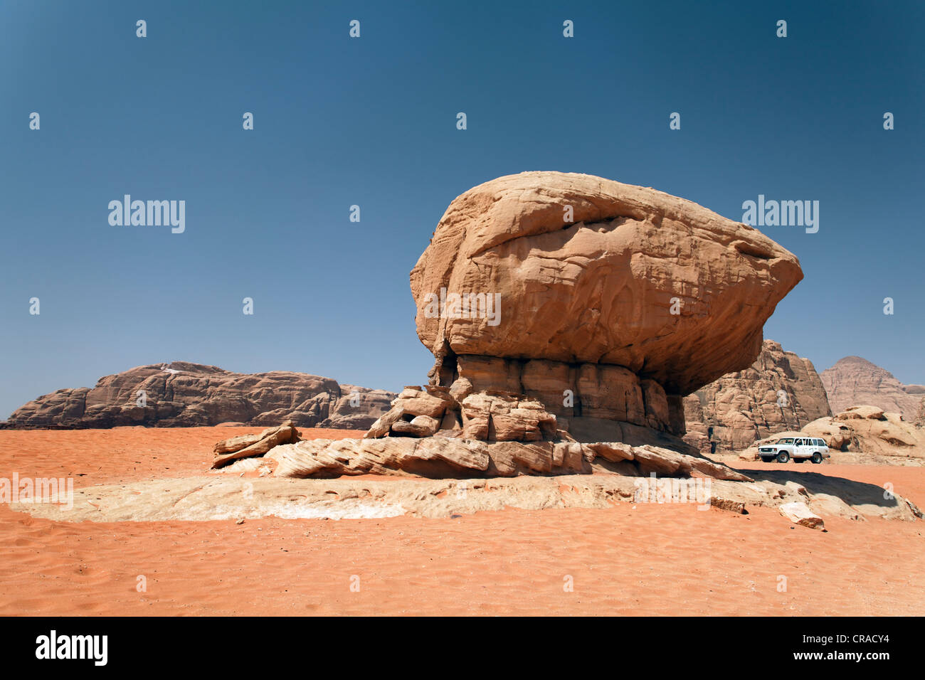 Véhicule hors route à côté d'un rocher en forme de champignon, sable rouge, désert, plaines, Wadi Rum, Royaume hachémite de Jordanie Banque D'Images