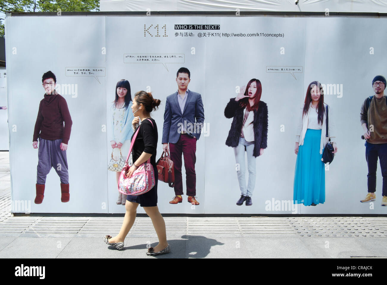 Les jeunes femmes chinoises en passant devant des panneaux publicitaires site de microblogging Weibo en Chine Shanghai Banque D'Images