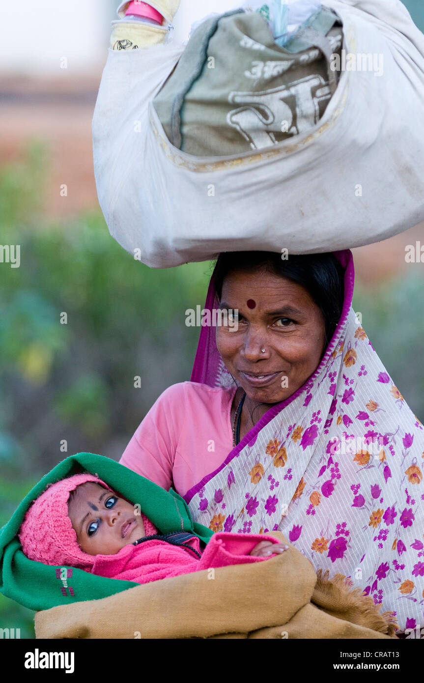 Femme avec enfant et la charge sur la tête, Orchha, Madhya Pradesh, Inde du Nord, Inde, Asie Banque D'Images
