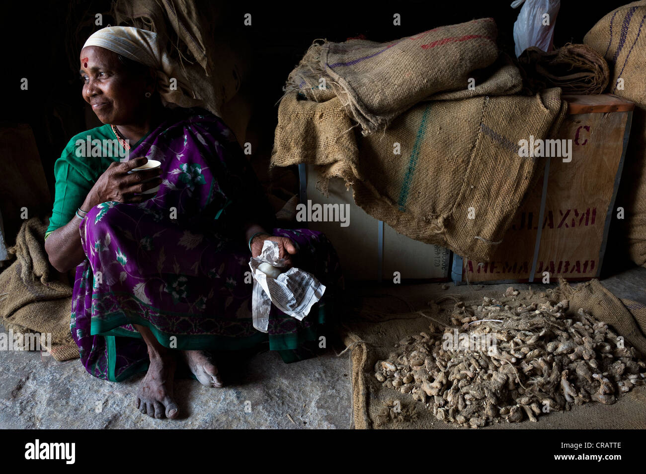 Travailleur féminin ayant une pause et de boire le thé dans une salle de stockage de gingembre, Juif Ville, Kochi, Cochin, Kerala, Inde du Sud, Inde Banque D'Images