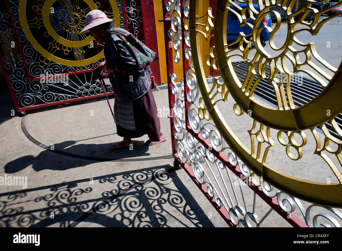 Vieille Femme d'entrer dans un bâtiment, l'installation des réfugiés tibétains à Bylakuppe, District de Mysore, Karnataka, Inde du Sud, Inde, Asie Banque D'Images