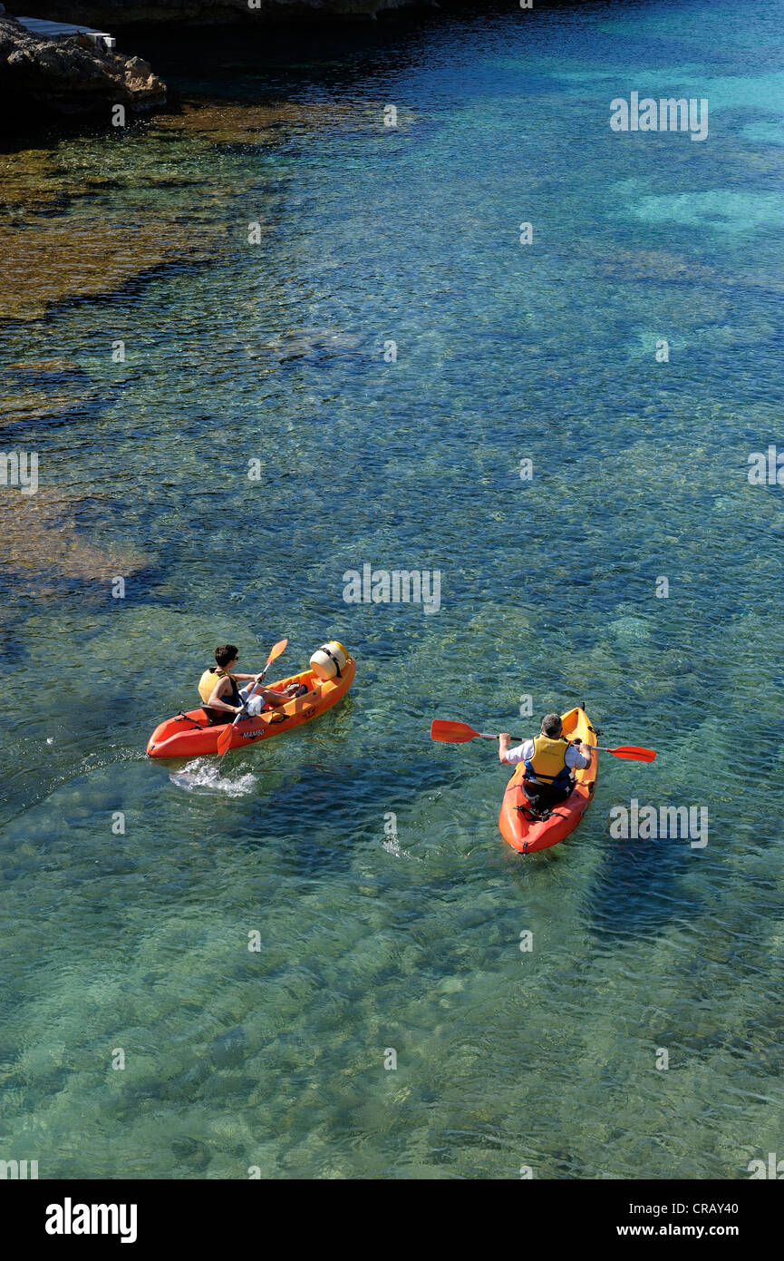 Père et fils en kayak dans les eaux cristallines de cala santa galdana menorca espagne iles baléares Banque D'Images