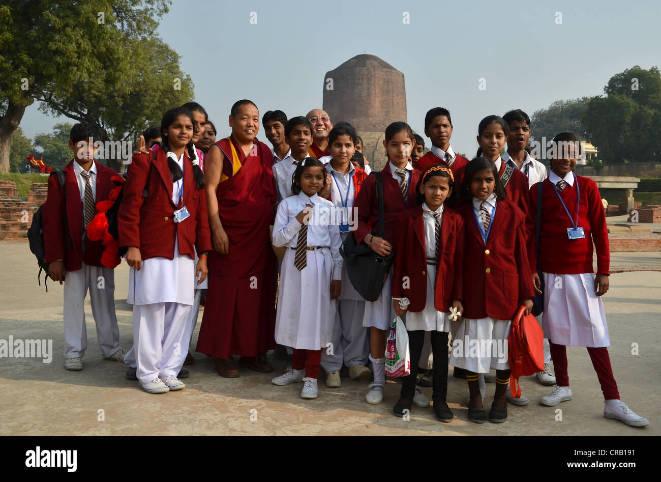 Les filles indiennes d'une classe d'école, dans une photo de groupe avec les moines tibétains et Rinpoché en face de Le Dhamekh Stoupa s Banque D'Images