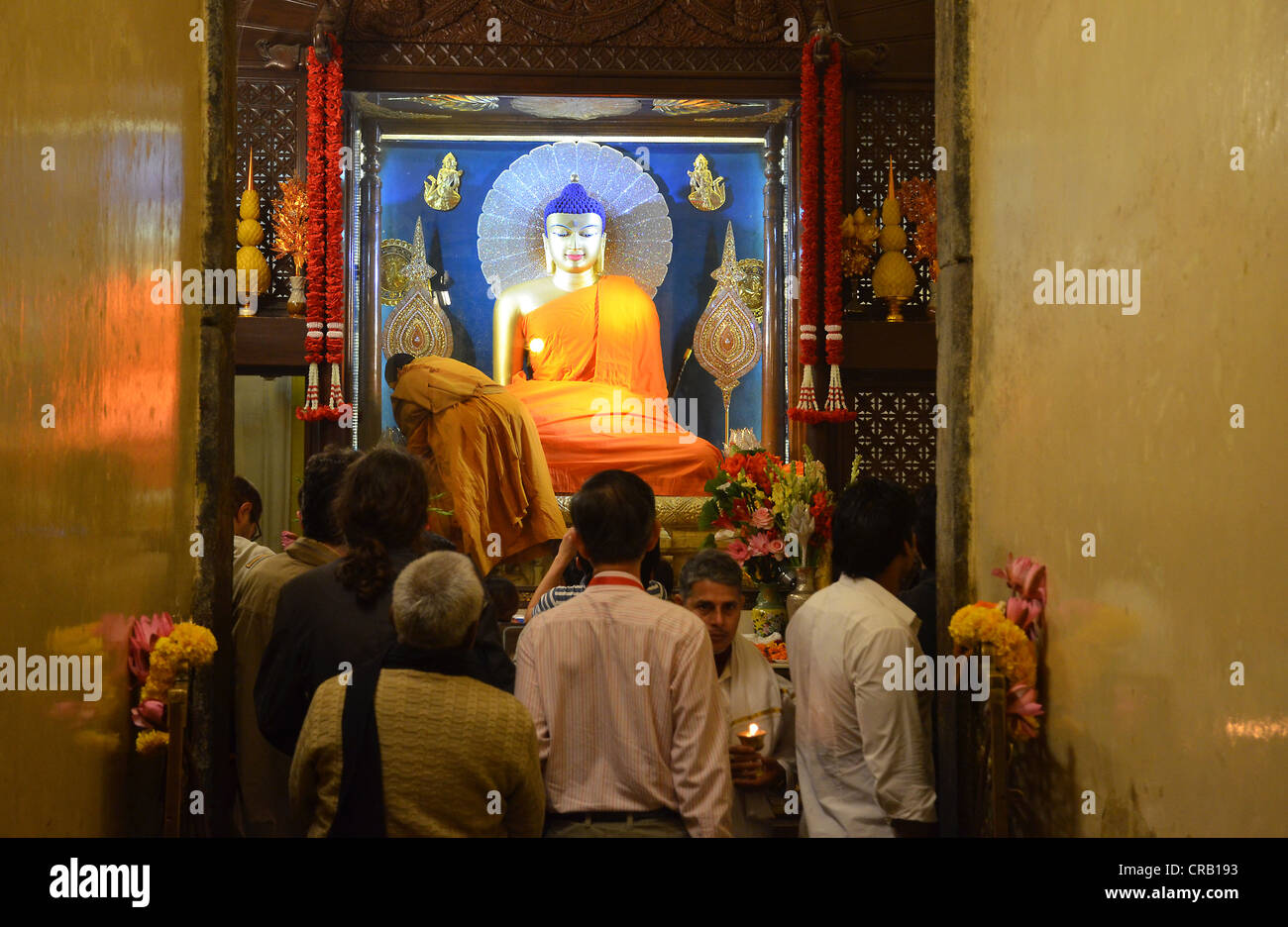 Pèlerins bouddhistes et les visiteurs à l'intérieur du Temple de la Mahabodhi sacrée, avec la statue de Bouddha Siddhartha Gautama qui à côté Banque D'Images