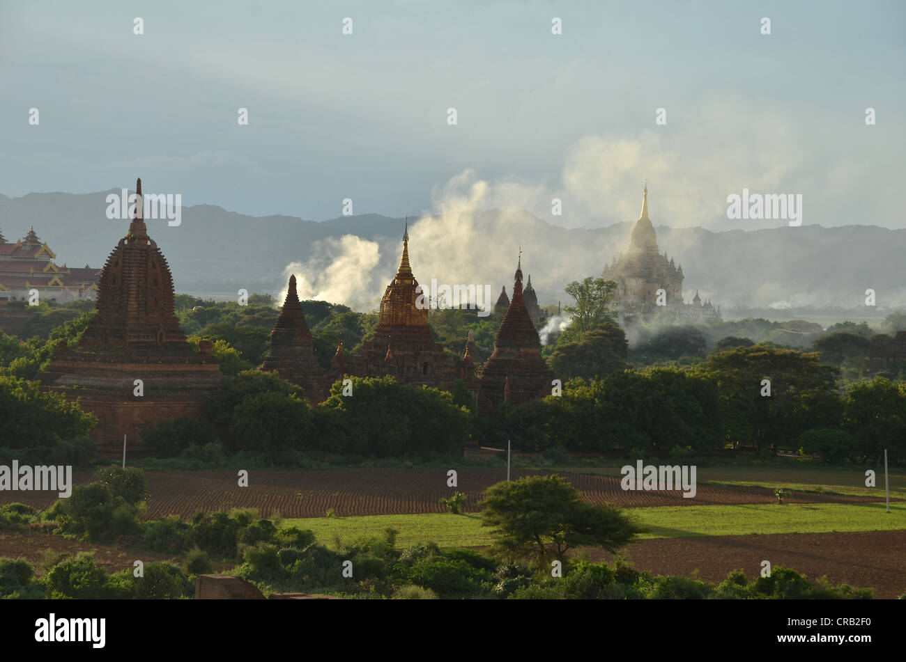 L'augmentation de la fumée entre les champs dans la lumière du soir, les temples et pagodes, Bagan, Myanmar, Birmanie, Asie du Sud, Asie Banque D'Images