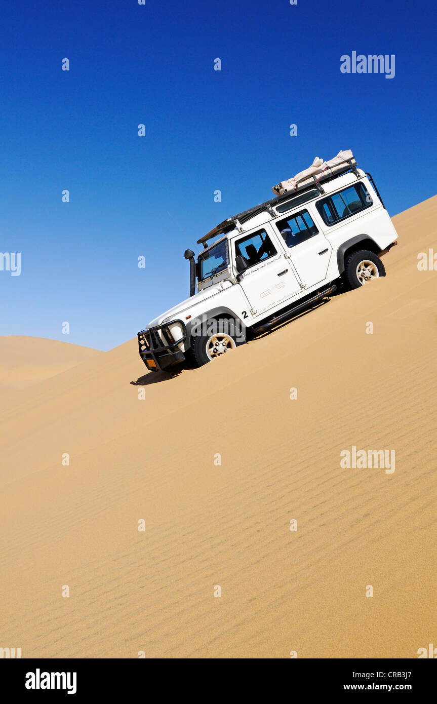 Landrover Defender véhicule hors route de descendre une immense dune, Namib-Naukluft National Park, Skeleton Coast National Park Banque D'Images