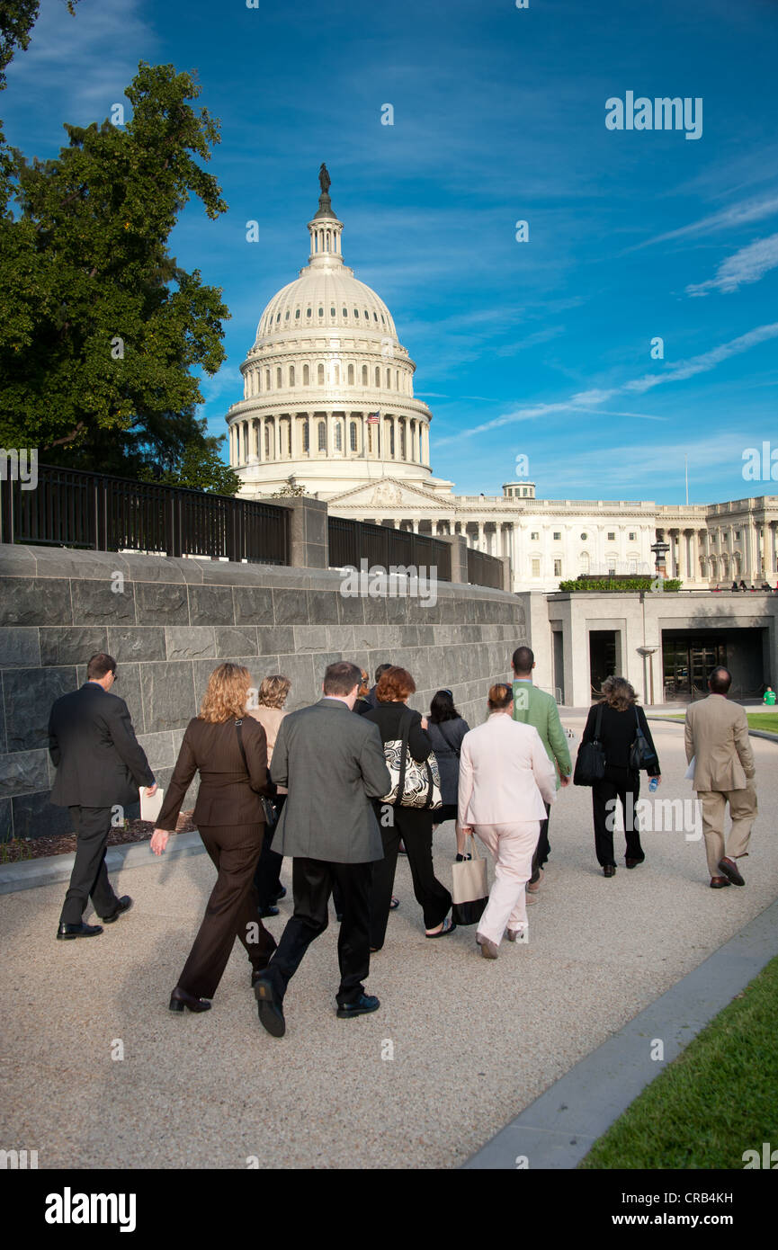 Groupe d'hommes d'affaires et d'une femme marchant à l'extérieur du bâtiment du Capitole à Washington DC Banque D'Images
