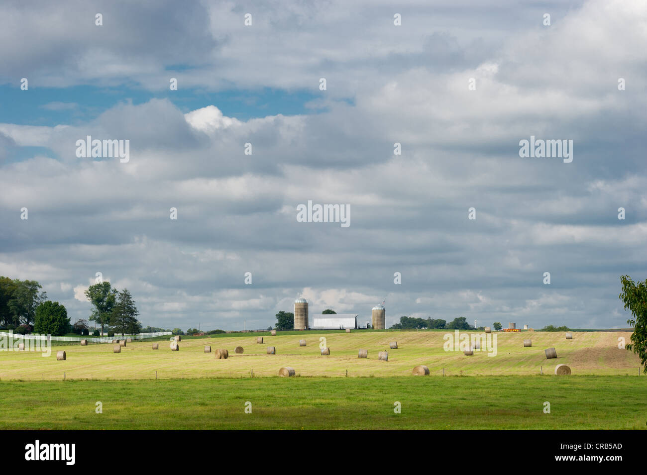 Voir des terres agricoles avec des ballots de foin, les silos et Grange sur terrain vert avec ciel bleu Banque D'Images