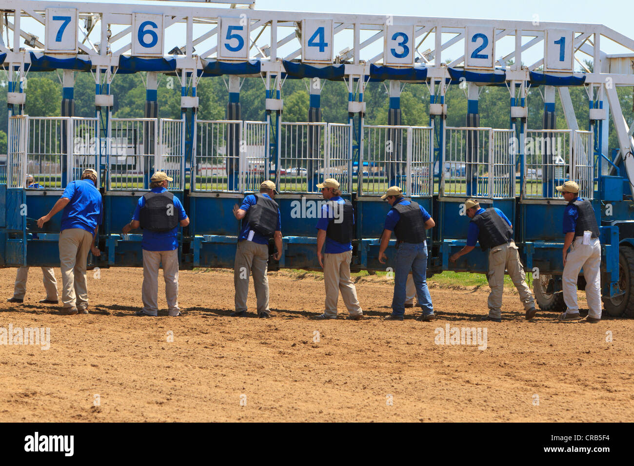 Préparer les employés Horsetrack gates pour le début d'une course de chevaux pur-sang. Banque D'Images