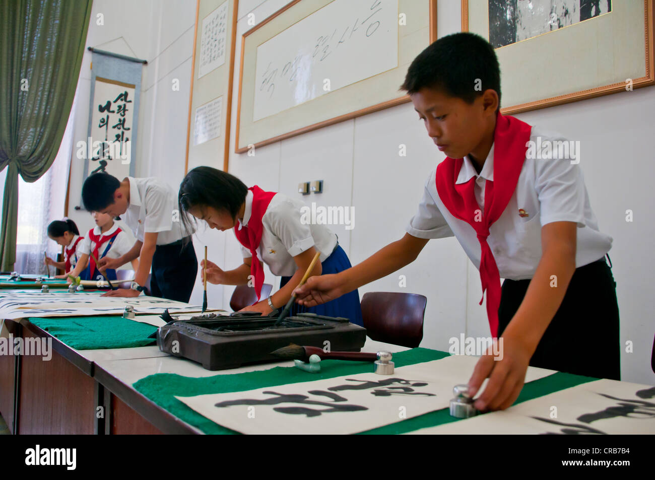 Certains enfants pratiquant la calligraphie dans le Palais des Enfants, Pyongyang, Corée du Nord, d'Asie Banque D'Images
