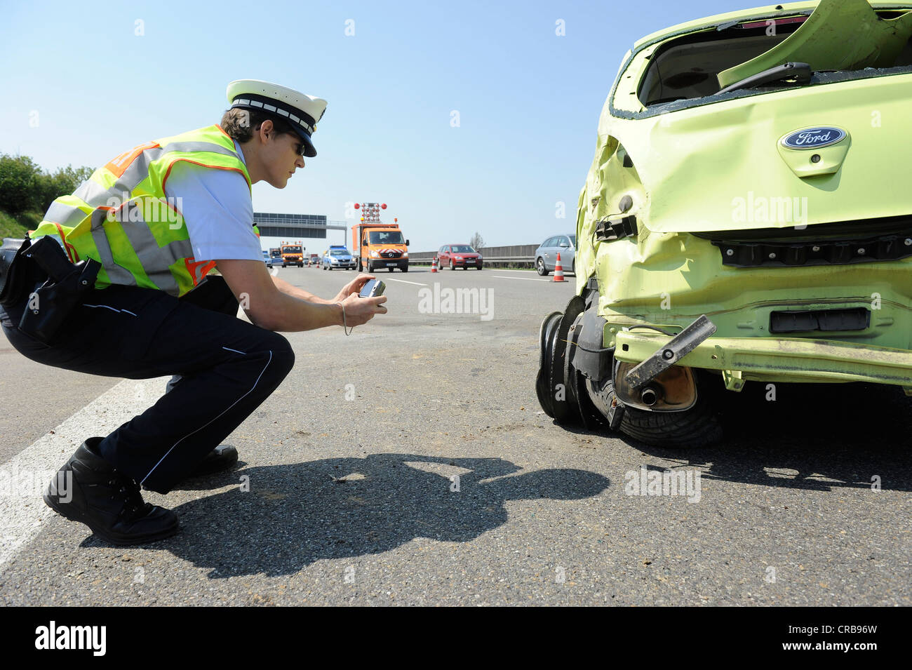 Policier à faire des photos de l'éclatement des pneus sur une Ford Ka après un accident de la circulation sur l'autoroute A8 entre Stuttgart-Flughafen et Banque D'Images