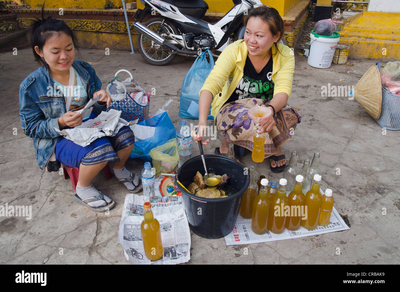 Deux femmes remplissant hydromel, miel vin en bouteilles, Vientiane, Laos, Indochine, Asie Banque D'Images