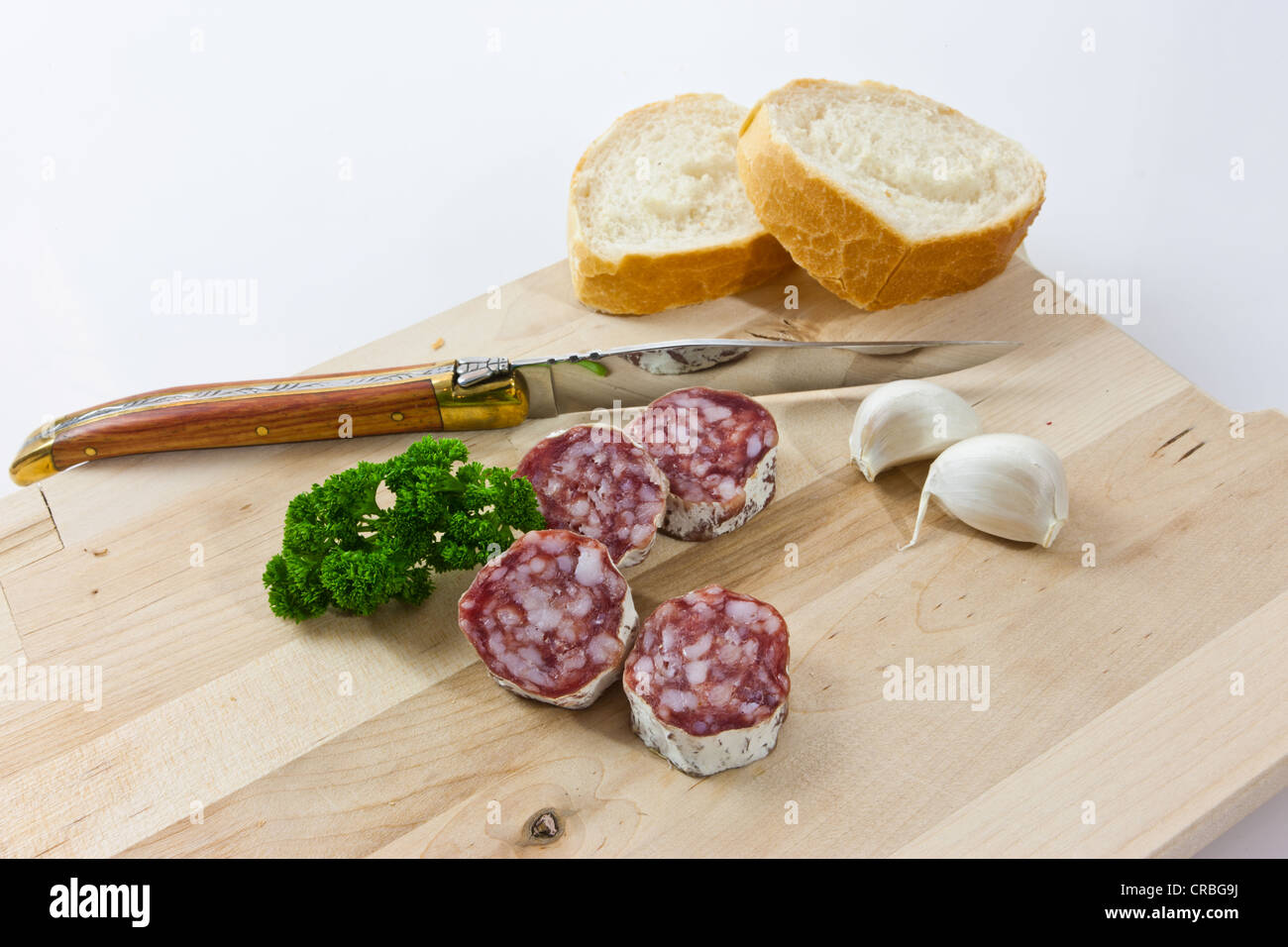 Salami salami premium gourmet, avec pain français, l'ail et au persil sur une planche en bois Banque D'Images