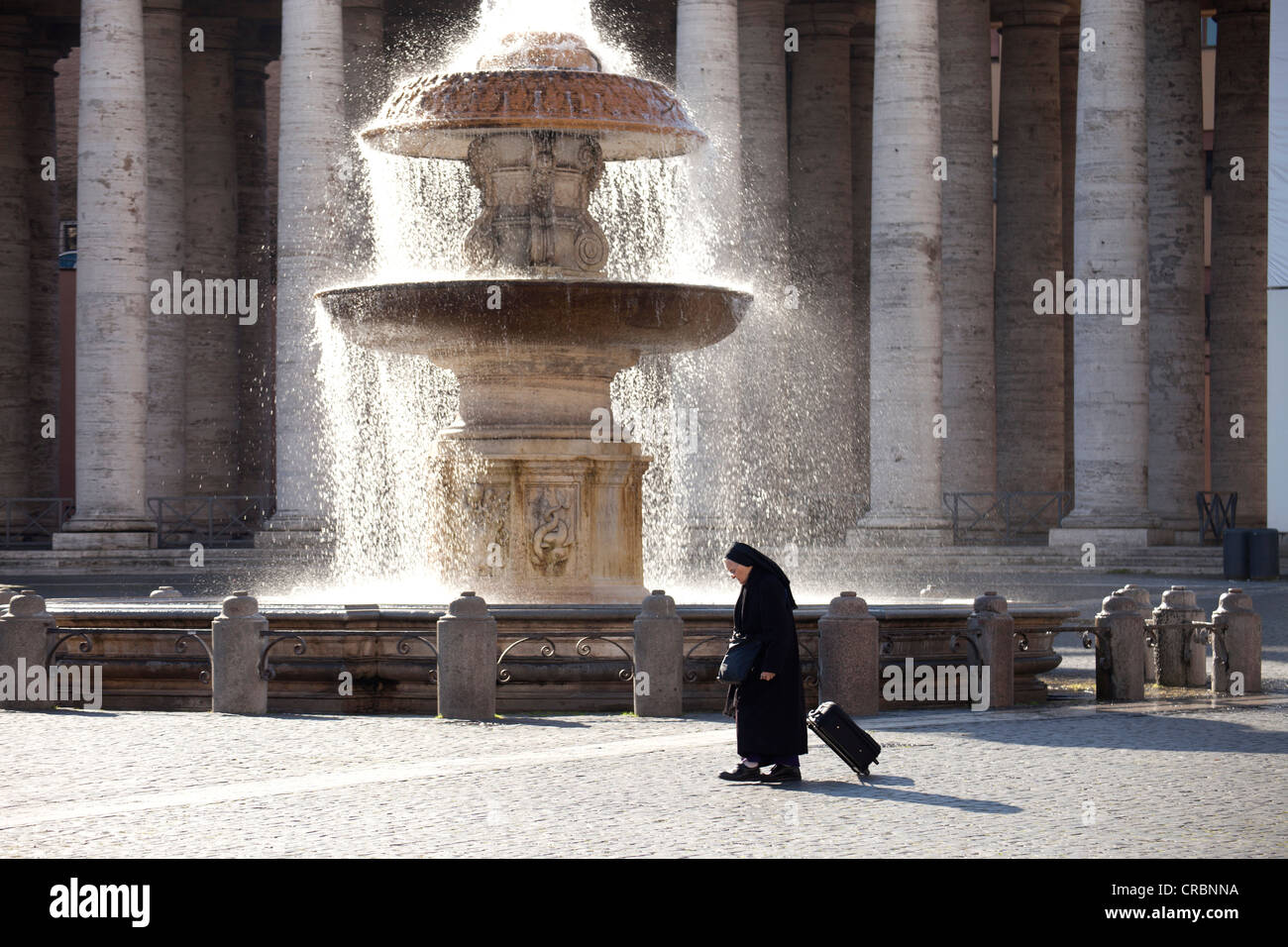 Nun en face d'une fontaine dans la place Saint Pierre à Rome, Italie, Europe Banque D'Images