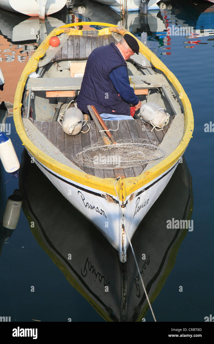 Vieux Pêcheur dans son bateau dans le port de Bardolino, sur le lac de Garde, Vérone province de Vérone, Vénétie, Italie, Europe Banque D'Images