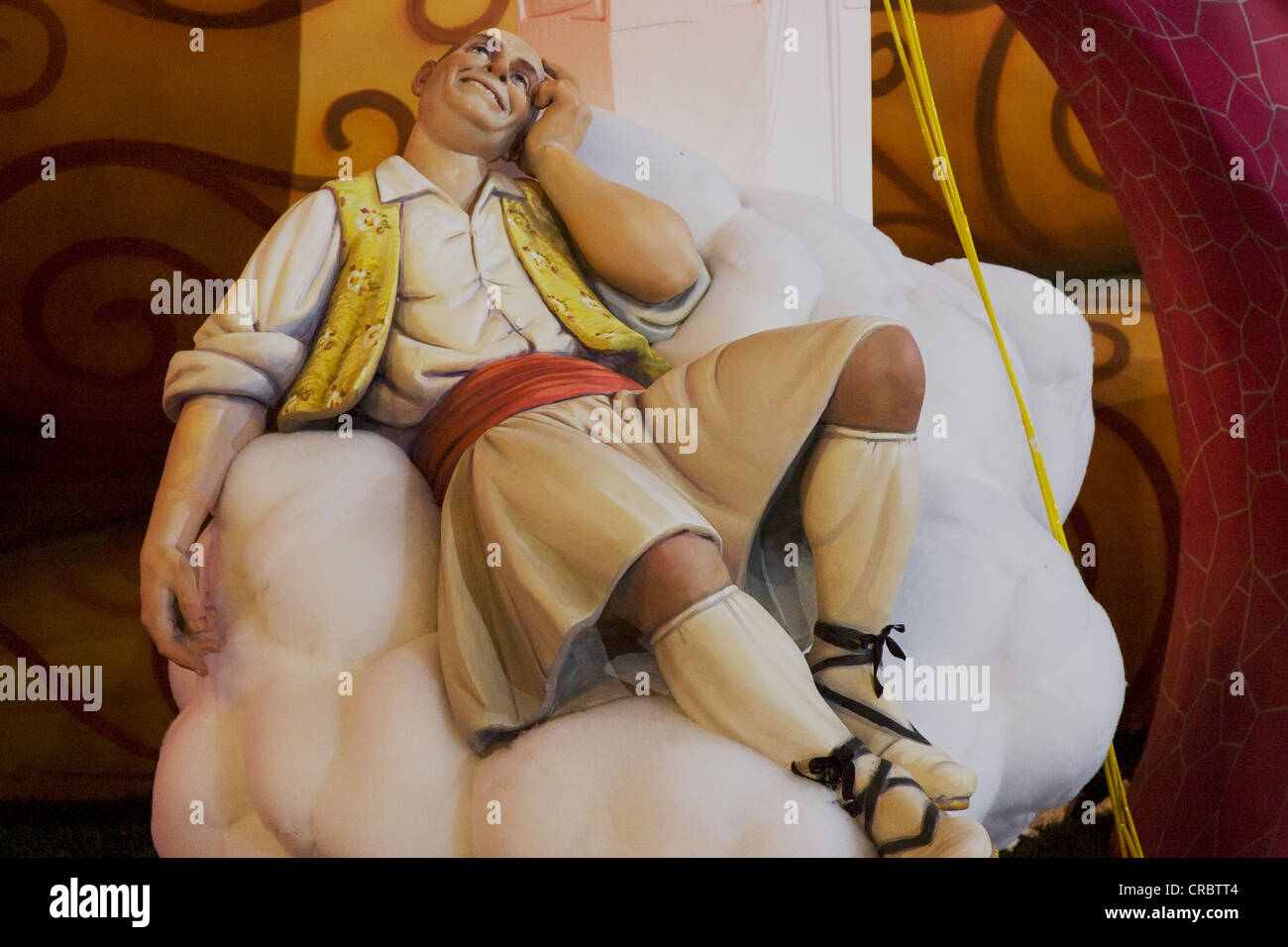 Homme portant une jupe, assis sur un nuage et de rêver, de pétrole brut, caractère carnaval sculpture satirique lors d'un défilé, Fallas Banque D'Images