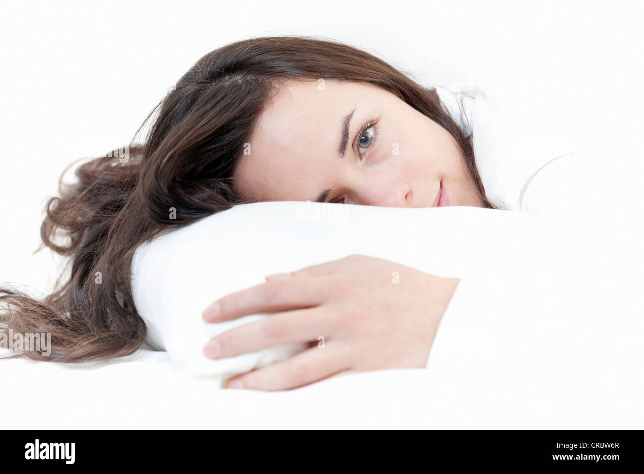 Smiling woman relaxing in bed Banque D'Images