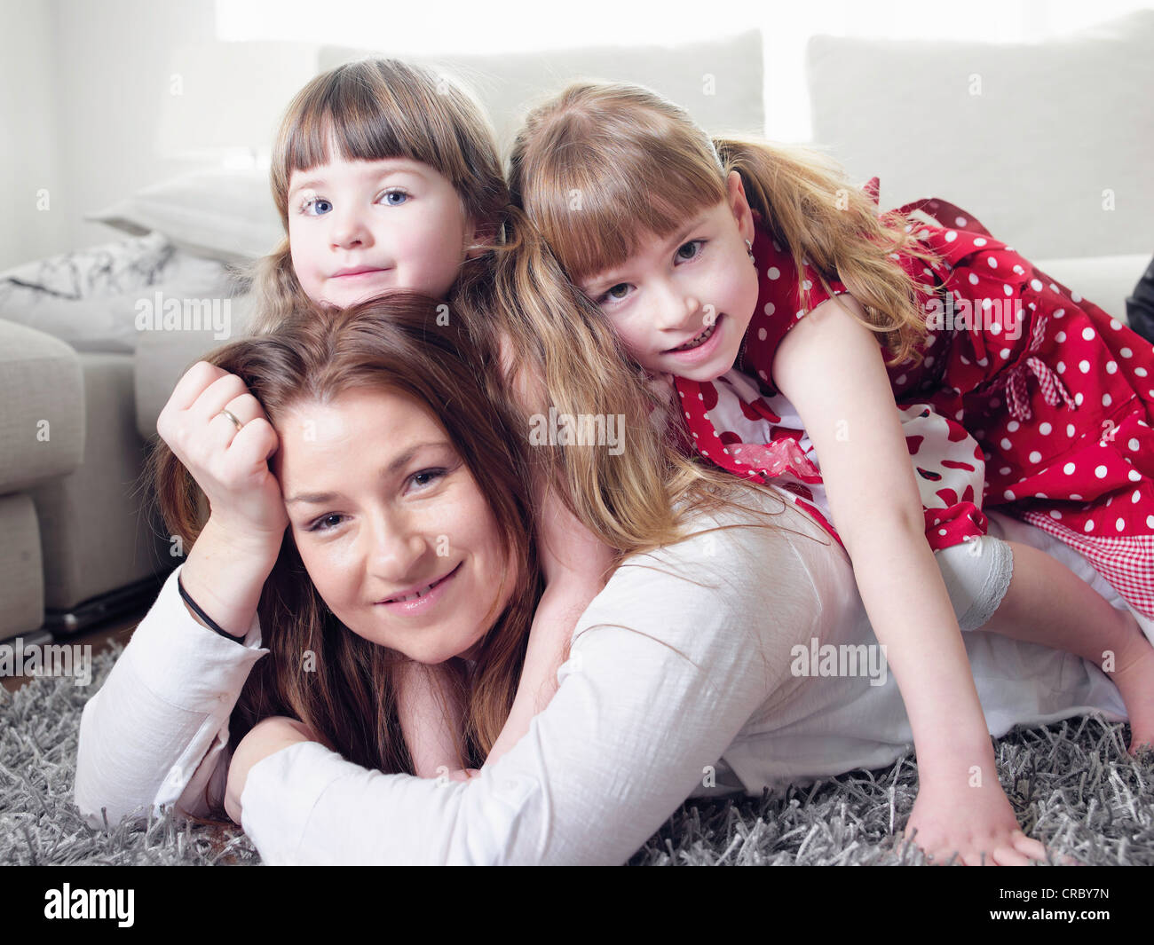 Mère et filles portant sur un tapis Banque D'Images