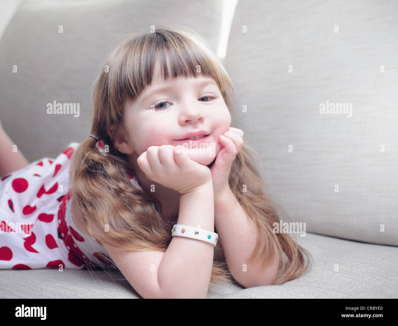 Smiling girl relaxing on sofa Banque D'Images