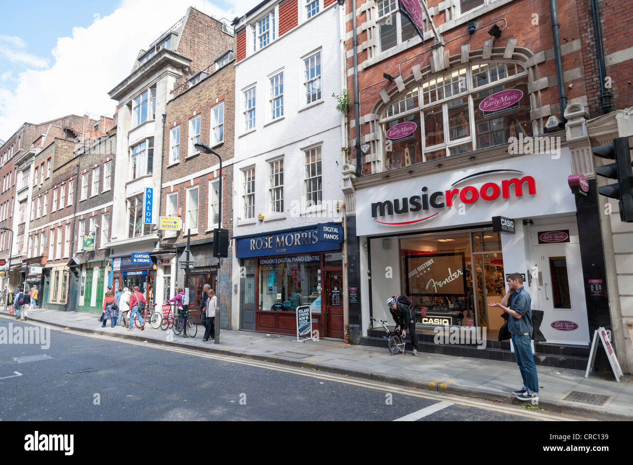 Scène de rue à Denmark Street London parfois appelé Tin Pan Alley célèbre pour ses nombreux magasins d'instruments de musique et de guitare Banque D'Images