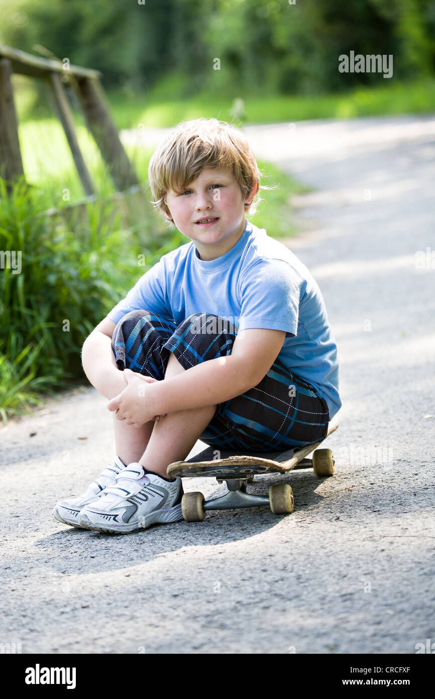 Garçon de 6 ans avec une planche à roulettes sur la promenade Banque D'Images