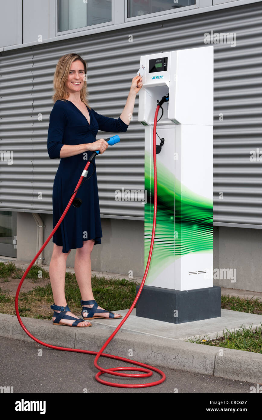 Femme tenant un code carte devant le lecteur d'une accusation CP700d'une station de charge par Siemens, Fürth, Bavière Banque D'Images
