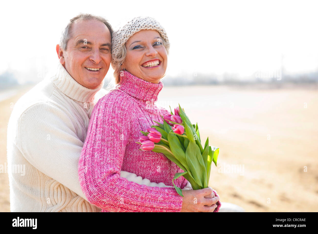 Heureux couple avec bouquet de tulipes en plein air Banque D'Images