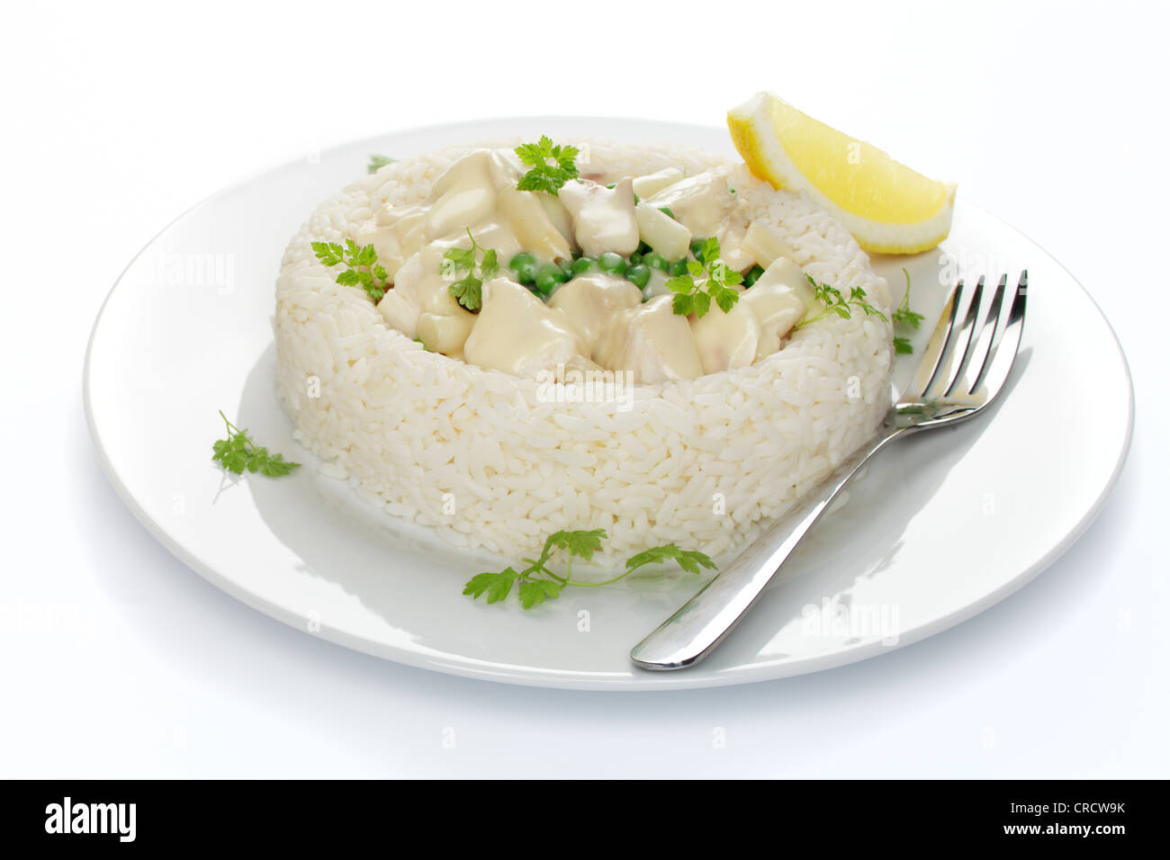 Fricassée de poulet aux asperges, petits pois et champignons dans un anneau de riz Banque D'Images