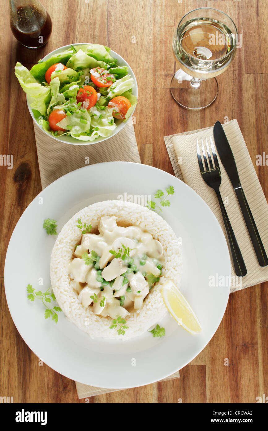 Fricassée de poulet aux asperges, petits pois et champignons dans un anneau de riz, salade, sauce Worcestershire, vin blanc Banque D'Images