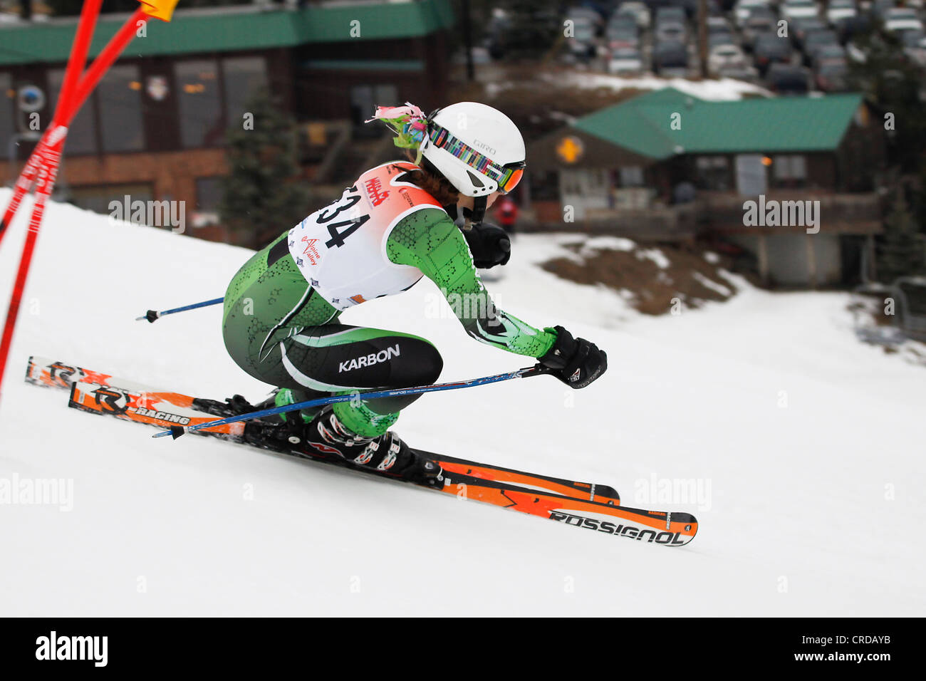 Une descente en ski de neige dans une course avec le chalet de ski en arrière-plan. Banque D'Images