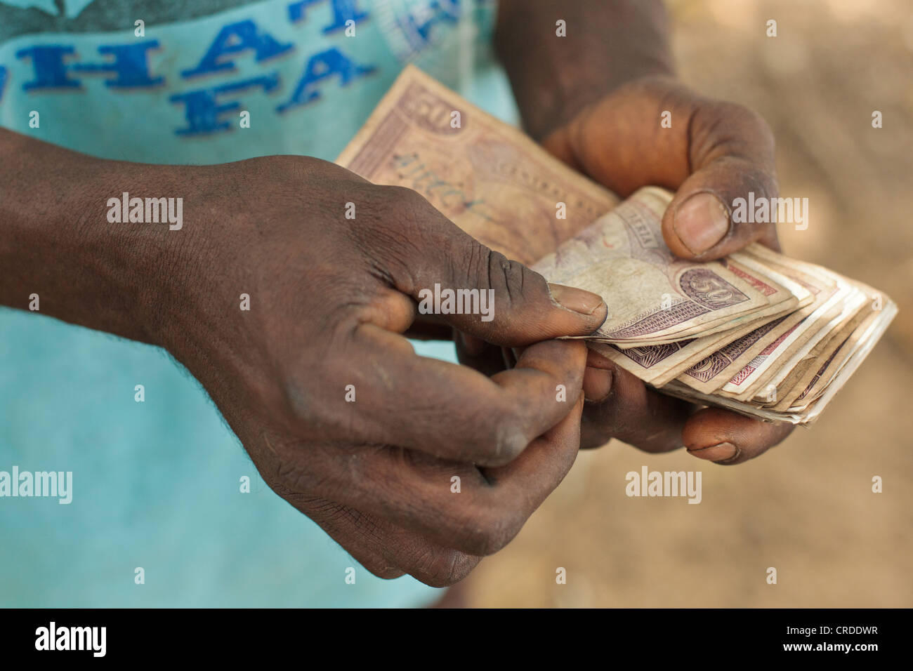 Un homme s'il venait juste de l'argent est reçu d'un programme de transferts sociaux dans le village d'Julijuah, Bomi, Libéria Banque D'Images