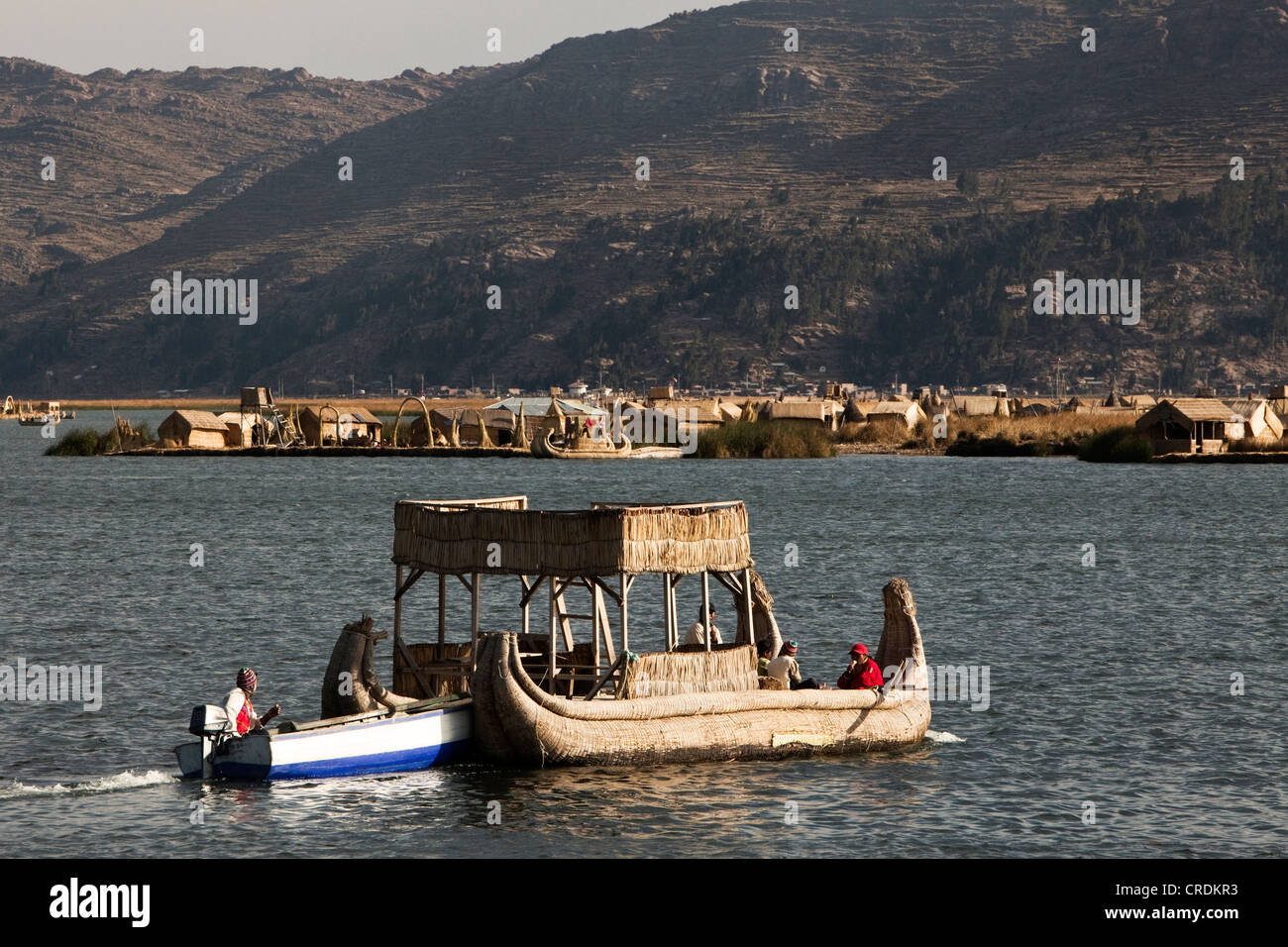 Reed traditionnel voile qui est poussé par un bateau motorisé, îles flottantes de l'Urus, sur le lac Titicaca, construit par les roseaux Banque D'Images