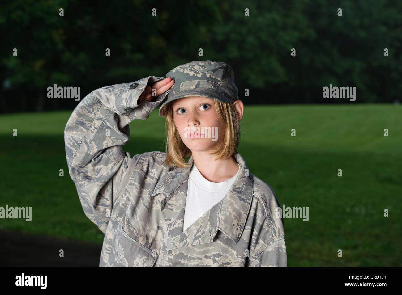 Jeune fille portant veste militaire et en saluant Banque D'Images