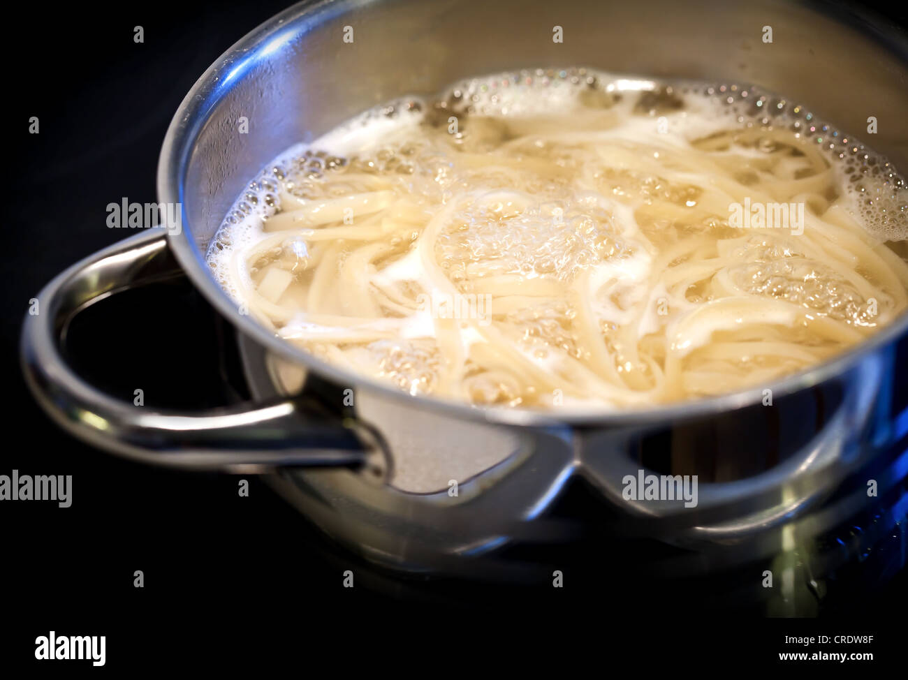 L'eau bouillante avec les nouilles dans la casserole en acier Banque D'Images