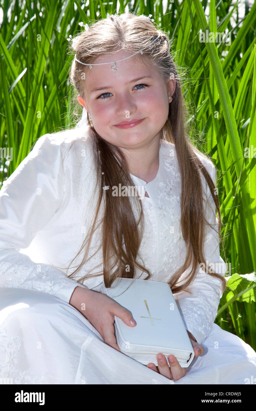 Communication, fille, 9 ans, debout sur l'herbe reed Banque D'Images